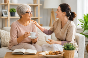 Senior woman talking with a caregiver at home during companion care